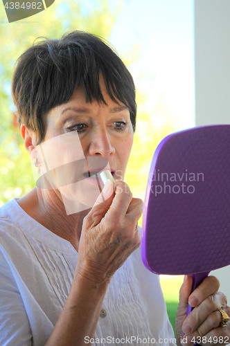 Image of Female applying makeup.