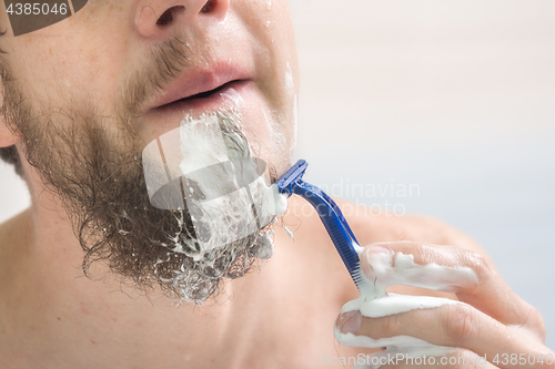 Image of The guy shaves his beard, close-up