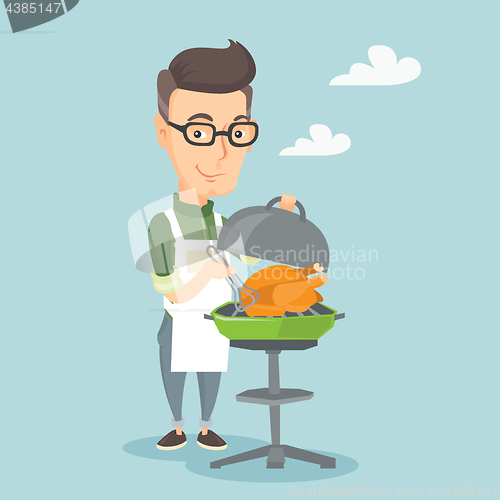 Image of Man cooking chicken on barbecue grill.