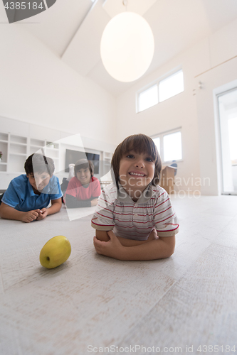 Image of boys having fun with an apple on the floor