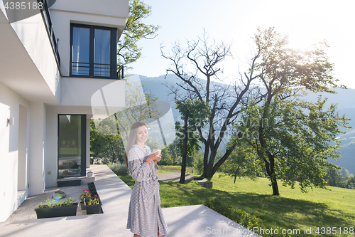 Image of woman in a bathrobe enjoying morning coffee