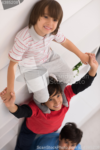 Image of young boys posing line up piggyback top view