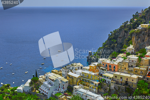 Image of One of the best resorts of Italy with old colorful villas on the steep slope, nice beach, numerous yachts and boats in harbor and medieval towers along the coast, Positano.