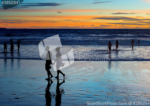 Image of Tropical ocean beach people sunset