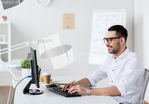 Image of businessman typing on computer keyboard at office