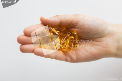 Image of hand holding cod liver oil capsules