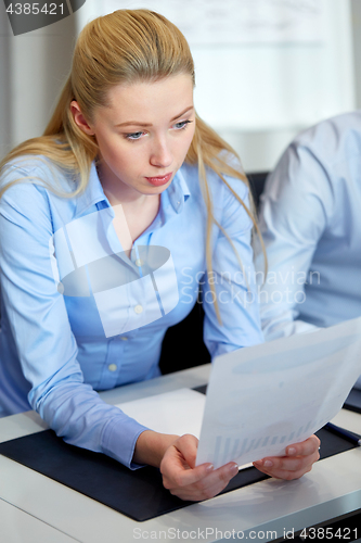 Image of businesswoman with papers working at office