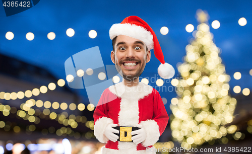 Image of man in santa claus costume over christmas lights