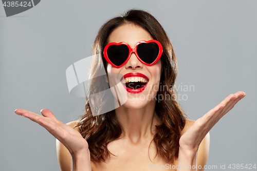 Image of woman with red lipstick and heart shaped shades