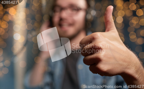 Image of singer showing thumbs up at sound recording studio