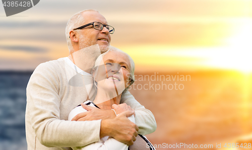 Image of happy senior couple over sunset background