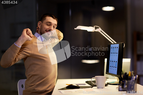 Image of man with computer working late at night office