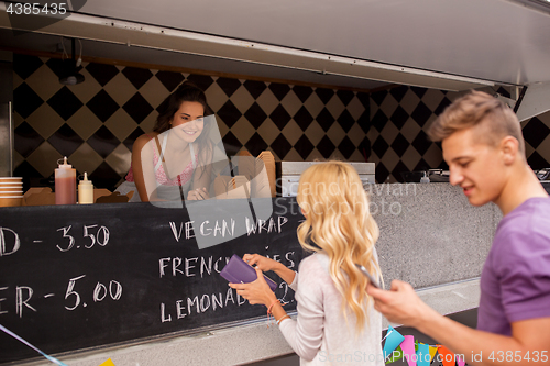 Image of happy customers queue at food truck