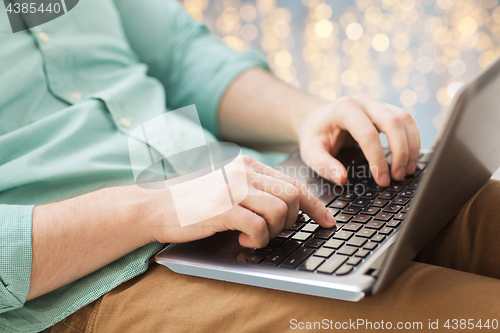 Image of close up of man typing on laptop keyboard