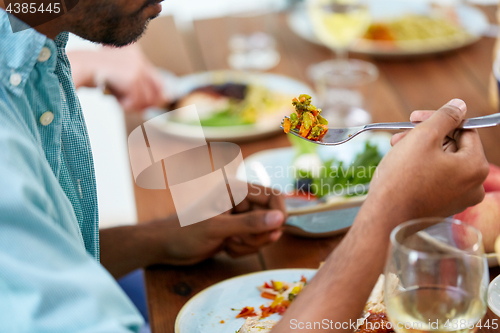 Image of close up of man with fork eating vegetables