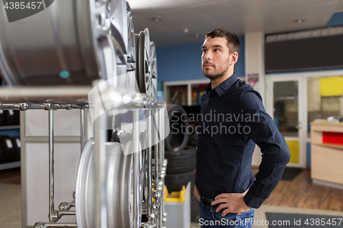 Image of male customer choosing wheel rims at car service