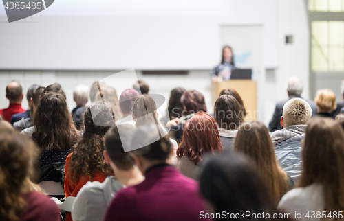 Image of Woman giving presentation in lecture hall at university.