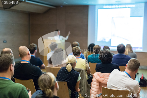 Image of Woman giving presentation in lecture hall at university.