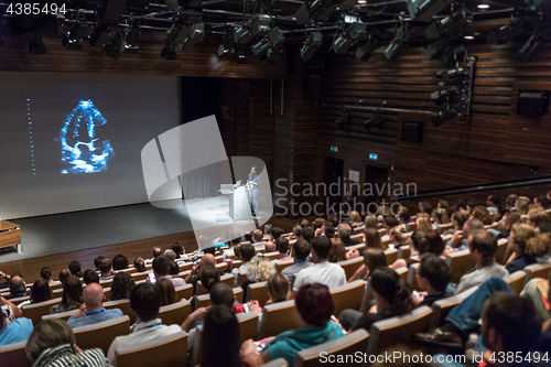 Image of Business speaker giving a talk in conference hall.