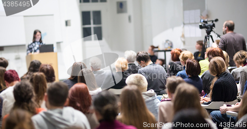 Image of Woman giving presentation in lecture hall at university.