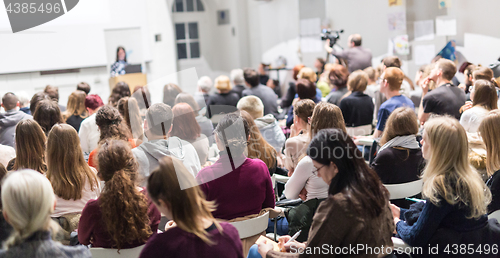 Image of Woman giving presentation in lecture hall at university.