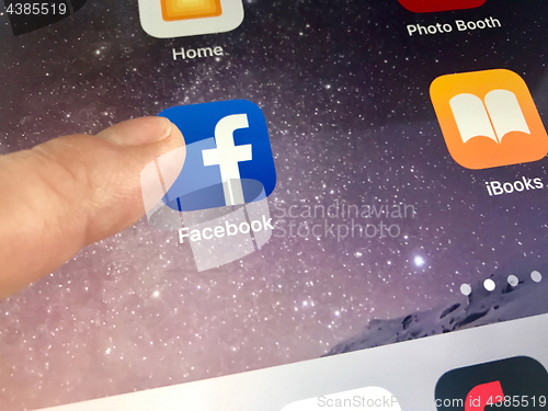 Image of Macro image of a finger about to click the Facebook icon on an iPad screen