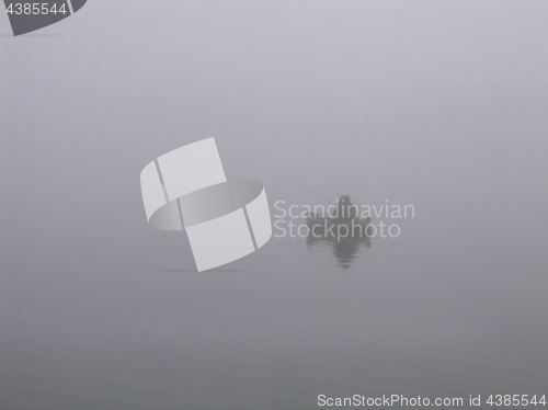 Image of Lone fisherman on the river in a fog