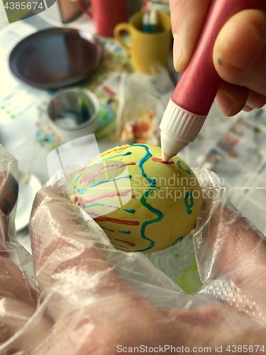 Image of Woman painting an easter egg for holiday