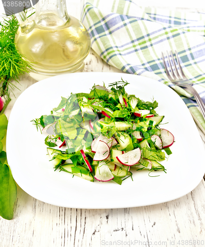 Image of Salad of radish and sorrel with oil in plate on board