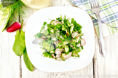 Image of Salad of radish and sorrel with oil in plate on light board top