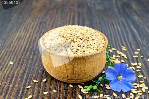 Image of Flaxen white seed in bowl with flower on board