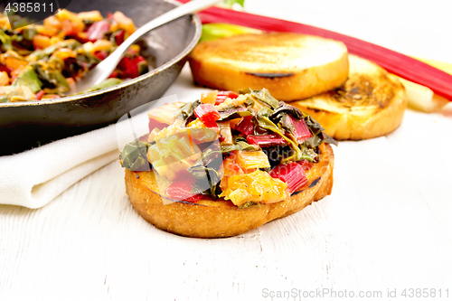 Image of Bruschetta with chard and orange on light board