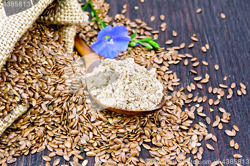 Image of Flour flax in spoon with flower on dark board