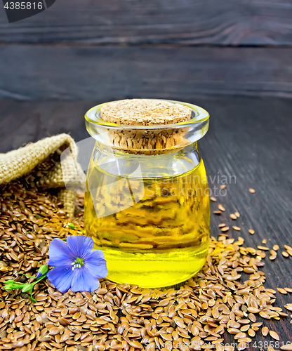 Image of Oil linenseed with flower and seeds on dark board