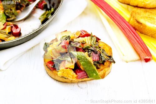 Image of Bruschetta with chard and orange on table