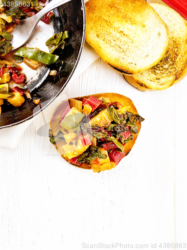 Image of Bruschetta with chard and orange on board top