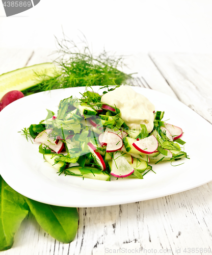 Image of Salad with radishes and sorrel in plate on wooden table