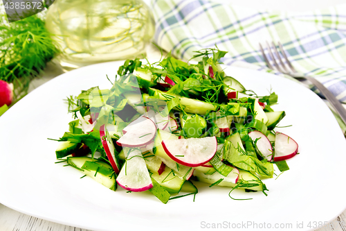 Image of Salad of radish and sorrel with oil in plate on table