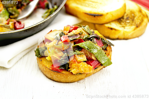 Image of Bruschetta with stewed chard and orange on light board