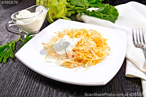 Image of Salad of carrot and kohlrabi with sour cream in plate on black b