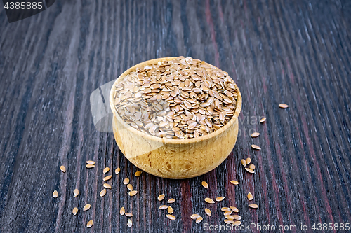 Image of Flaxen brown seed in bowl on board