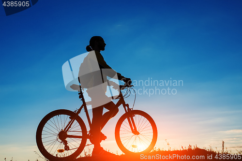 Image of Silhouette of a bike on sky background