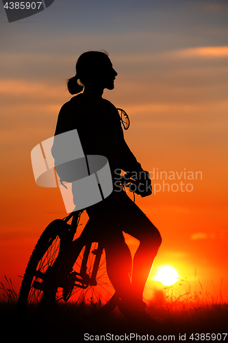 Image of Silhouette of a bike on sky background