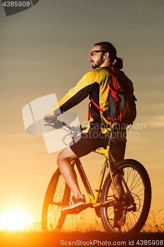 Image of Man in helmet and glasses stay on the bicycle