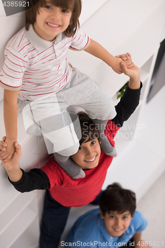 Image of young boys posing line up piggyback top view