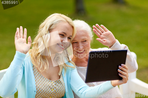 Image of daughter with tablet pc and senior mother at park