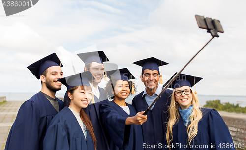 Image of group of happy students or graduates taking selfie