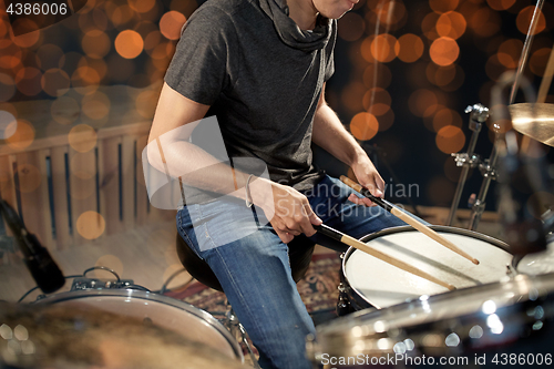 Image of musician or drummer playing drum kit at concert