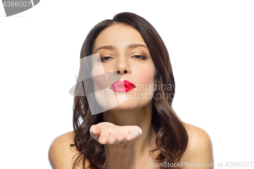 Image of beautiful woman with red lipstick blowing air kiss