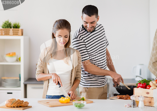 Image of couple cooking food at home kitchen